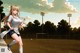 A woman in a white shirt and black shorts playing soccer.