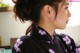 A woman wearing a black kimono with purple flowers on it.