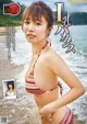 A woman in a bikini standing on a beach.