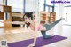 A woman doing a yoga pose on a purple mat.