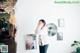 A woman standing in front of a wall with pictures on it.