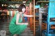 A woman in a green dress sitting at a table.