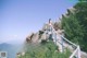 A woman standing on top of a mountain next to a railing.